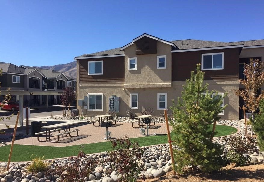 a large house with a picnic area in front of it