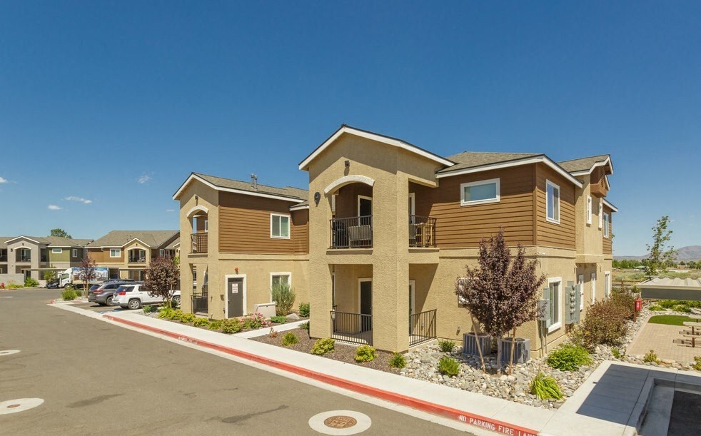 a row of apartment buildings with a parking lot