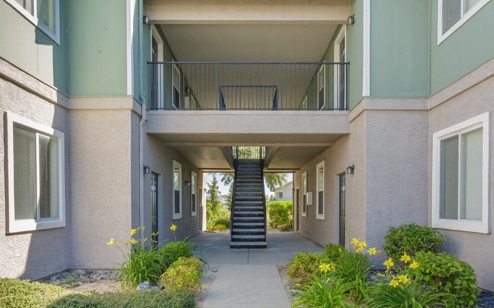 a covered walkway leading to a building with a staircase
