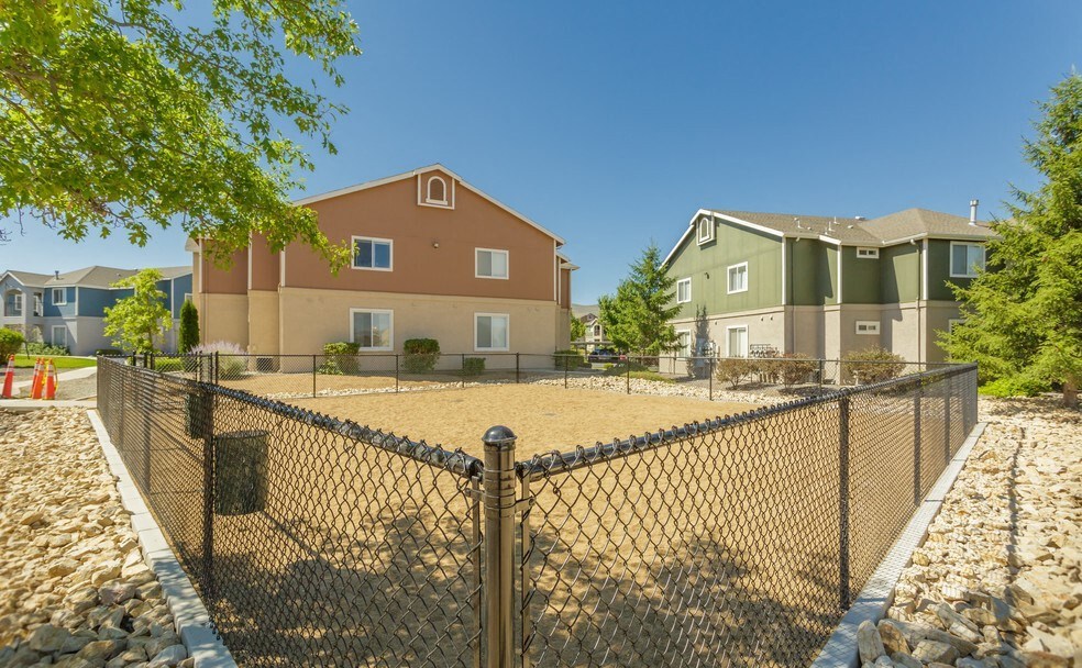 a fenced in area with apartments behind a chain link fence