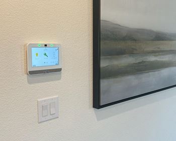 a thermostat on a wall next to a painting