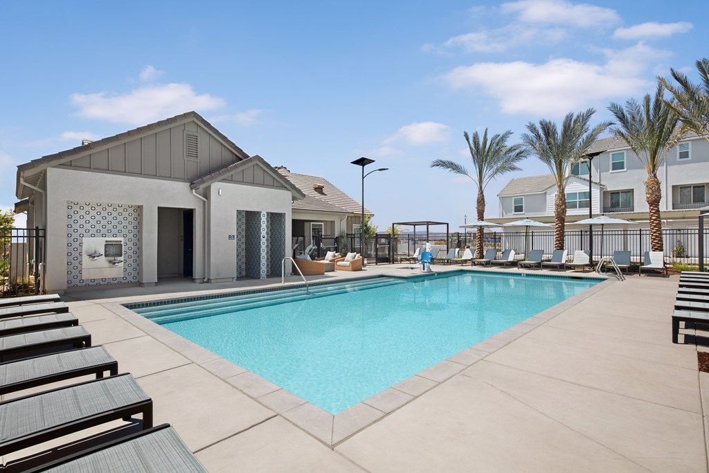 Roseville Apartments in California - Solstice at Fiddyment Ranch - Resort-Style Pool with a Spa, Lounge Chairs, Cabanas, Patio Chairs, Fire Pit, Drinking Fountains, and Palm Trees