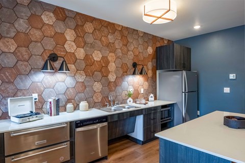 a kitchen with a large counter and a stainless steel refrigerator