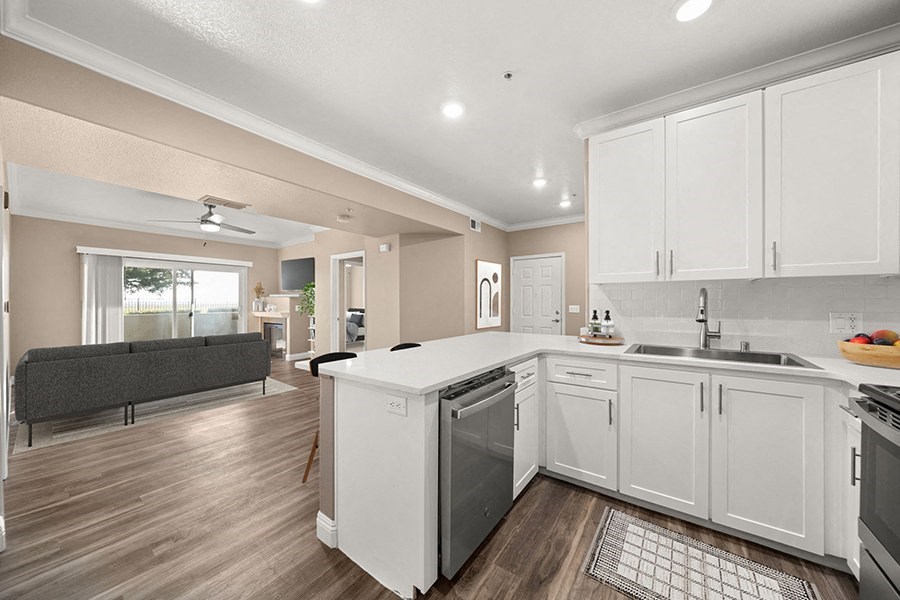 a kitchen and living room with white cabinets and a counter top