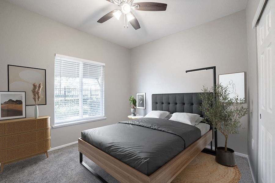 an empty bedroom with a bed and a ceiling fan