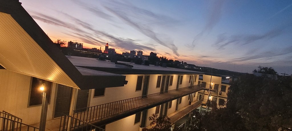 the view of the city from the roof of a building at sunset