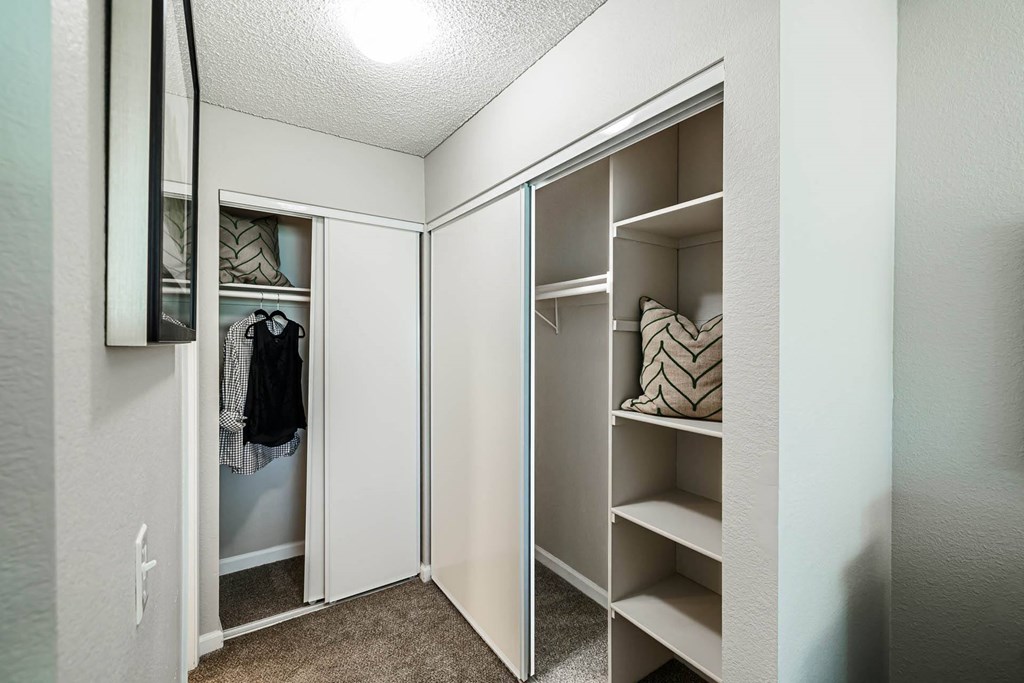 a closet in a bedroom with a mirrored closet door at SYCAMORE GREENS APARTMENT HOMES, Vista, 92081