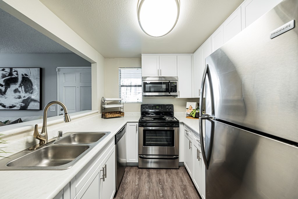 A modern kitchen with stainless steel appliances and white cabinets.