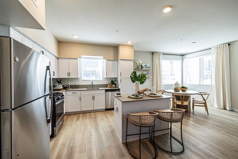 a kitchen and dining area with stainless steel appliances and a table and chairs
