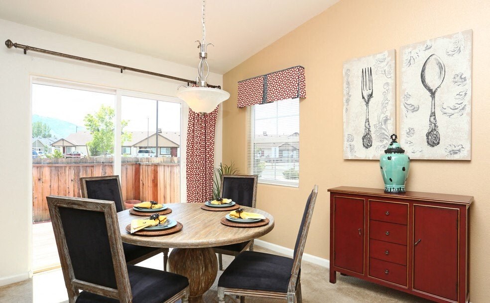 a dining room with a table and chairs and a window