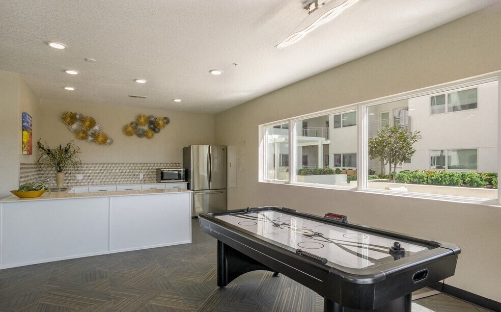 a game room with a pool table and a kitchen