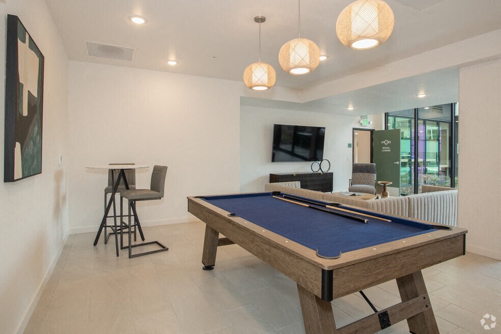 a pool table in a living room with a bar and a tv at THE MOD AT MIDTOWN Apartments, SACRAMENTO