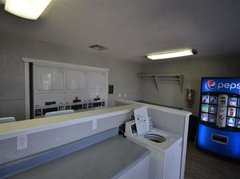 a washer and dryer are in a room with a vending machine at DESERT PEAKS, EL PASO, 79912