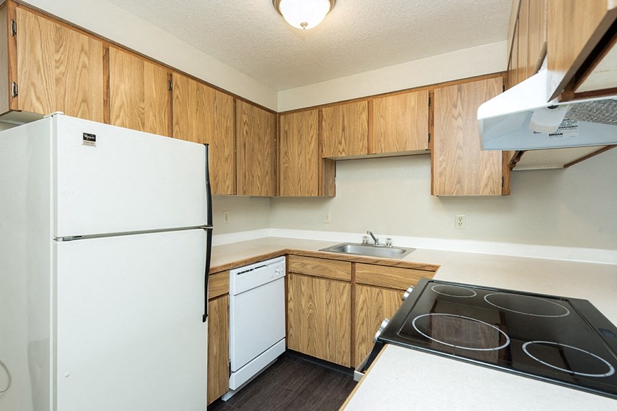 Apartments in Gresham, OR- Township Eastside- Wood-Style Cabinets with Electric Stove and White Refrigerator