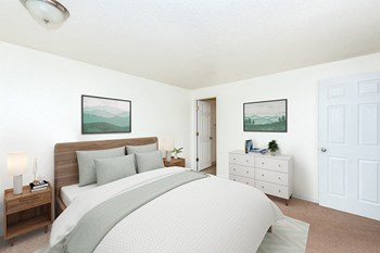 Two-Bedroom Apartments in Gresham, OR- Township Eastside- Large Bed with White Dresser and Wall-to-Wall Carpeting - Photo Gallery 14