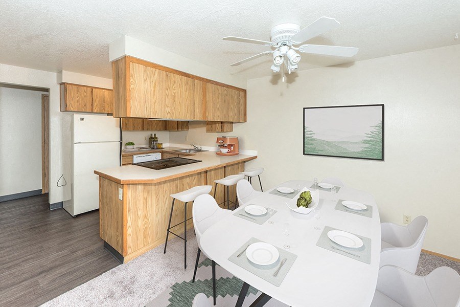 Gresham Apartments- Township Eastside-  Large Dining Room Table with White Ceiling Fan and Grey Area Rug