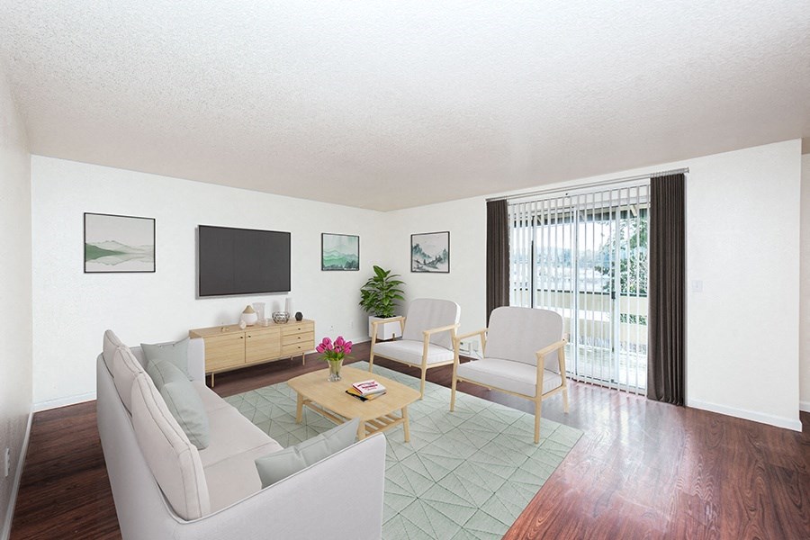 2 BR Apartments in Gresham OR - Township Eastside - Living Room with Wood-Style Flooring, Couch, Chairs, Coffee Table, Area Rug, TV, and Sliding Glass Door
