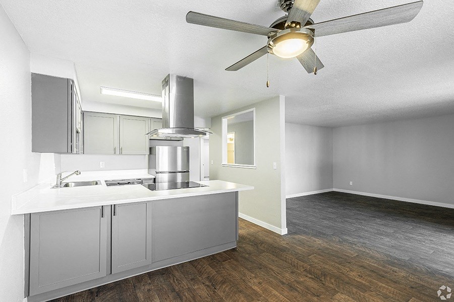 a kitchen and living room with a ceiling fan