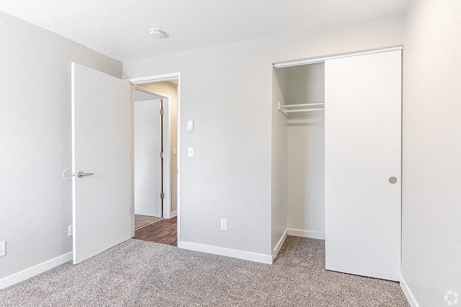a bedroom with white walls and carpet