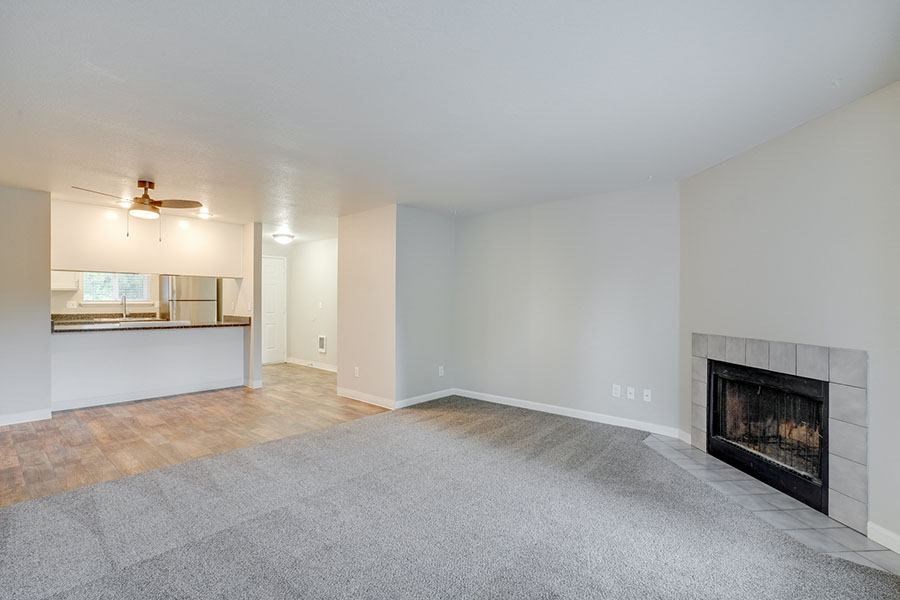 Living Room with Plush Carpeting and an Interior Fireplace at TOWNSHIP Apartments, CANBY, Oregon