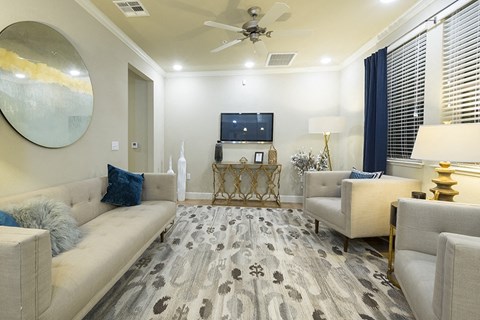 A living room with a grey carpet and a white sofa.