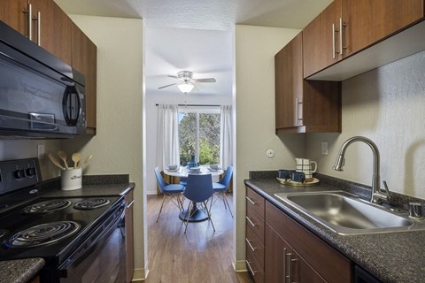 a kitchen with a sink and a stove and a dining room table