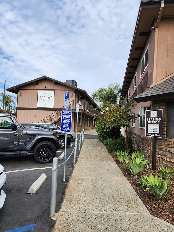Sidewalk by buildings and parking
