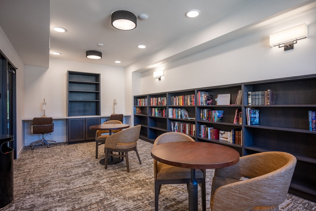 a library with tables and chairs and shelves of books at Vintage at Anacapa Canyon, Camarillo