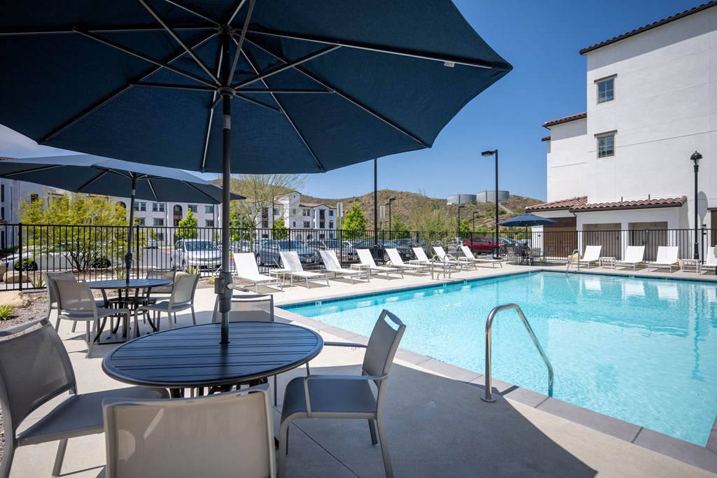 a swimming pool with tables and chairs and umbrellas at Vintage at Anacapa Canyon, Camarillo, CA