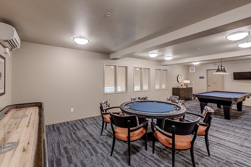 A room with a pool table and a shuffleboard table.