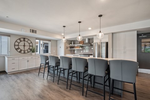 a kitchen with a large island and chairs in front of a kitchen counter