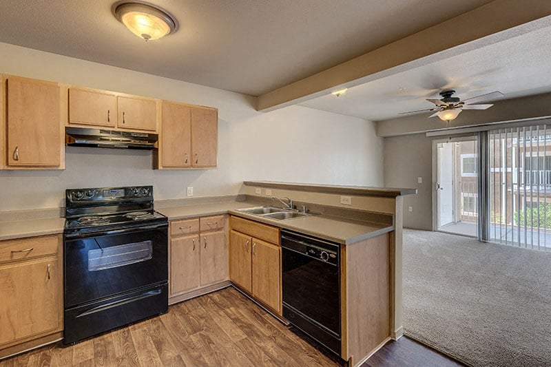 A kitchen with wooden cabinets and black appliances.