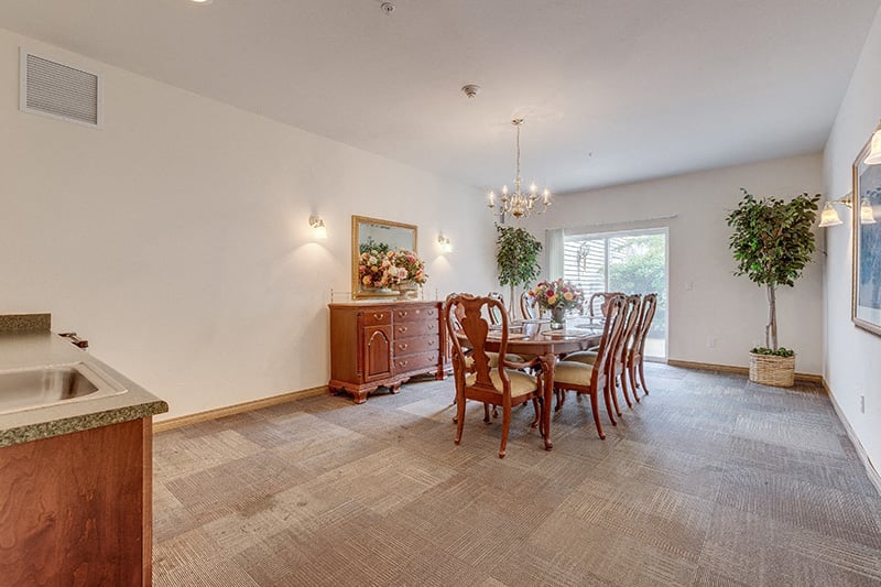 A dining room with a wooden table and chairs.