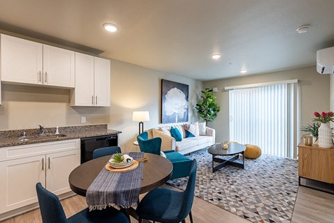 A modern kitchen with a dining table set for two.