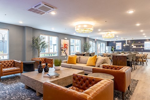 A living room with brown leather furniture and a fireplace.