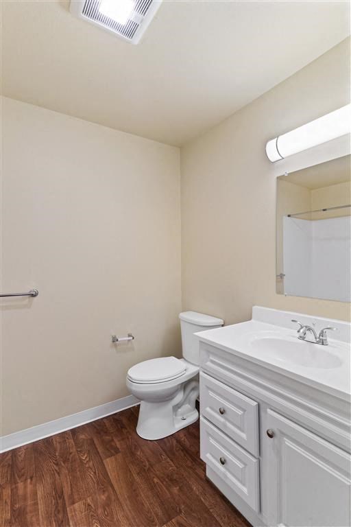 a bathroom with a toilet sink and mirror at Webster Court Senior Apartments, Kent Washington