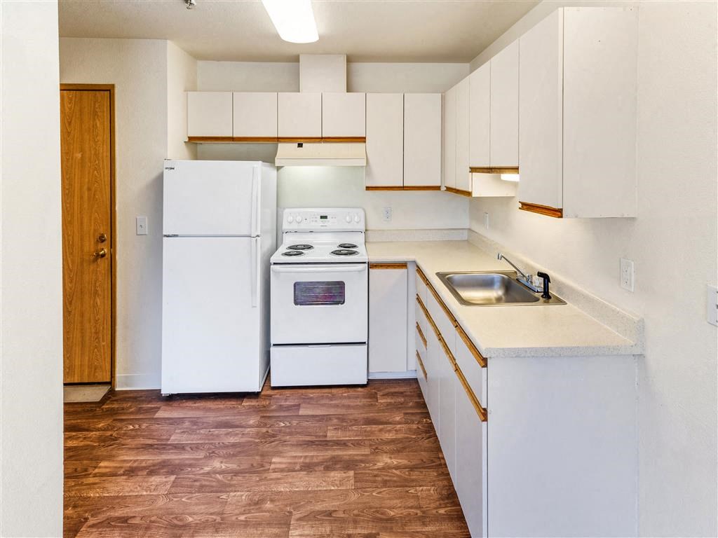 a kitchen with white appliances and a wooden floor at Webster Court Senior Apartments, Kent