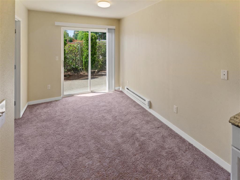 an empty room with a sliding glass door at Webster Court Senior Apartments, Washington, 98032