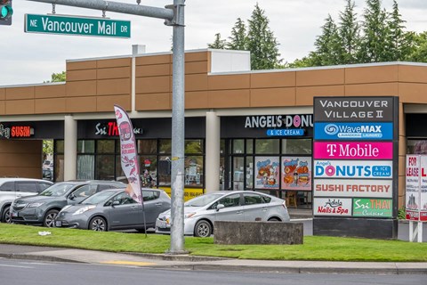 A parking lot with cars and a building with a sign that says Vancouver Mall.at Vancouver Mall Apartments, Vancouver