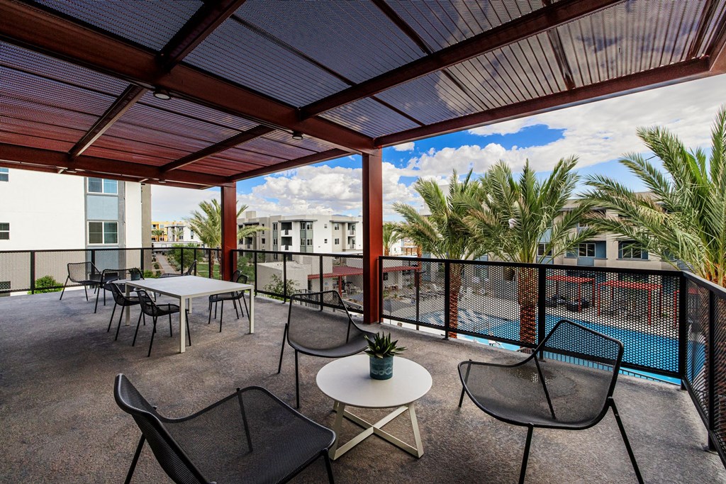 a rooftop patio with tables and chairs and a pool at BASE APARTMENT HOMES, LAS VEGAS, NV
