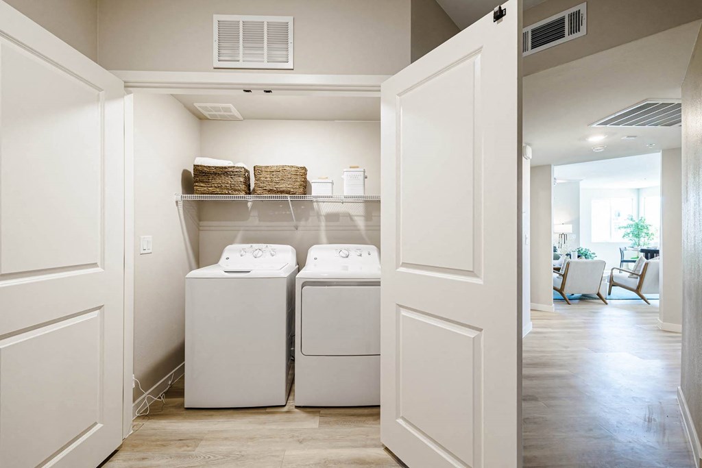 a washer and dryer in a laundry room with white doors at BASE APARTMENT HOMES, Nevada