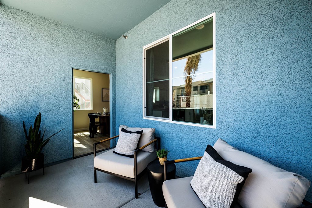 a living room with a blue wall and a large window at BASE APARTMENT HOMES, LAS VEGAS, 89166