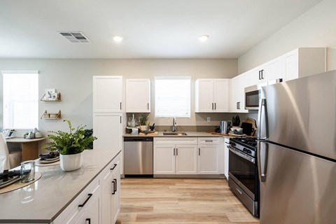 a kitchen with stainless steel appliances and white cabinets