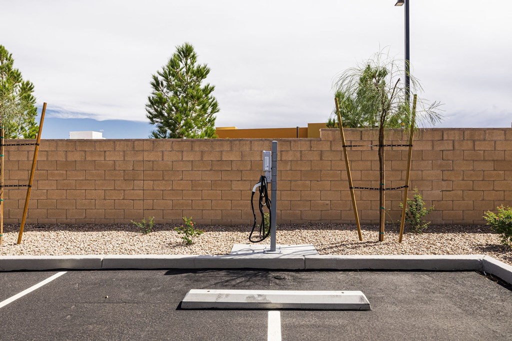 a water hydrant in a parking lot in front of a brick wall at BASE APARTMENT HOMES, LAS VEGAS, NV 89166