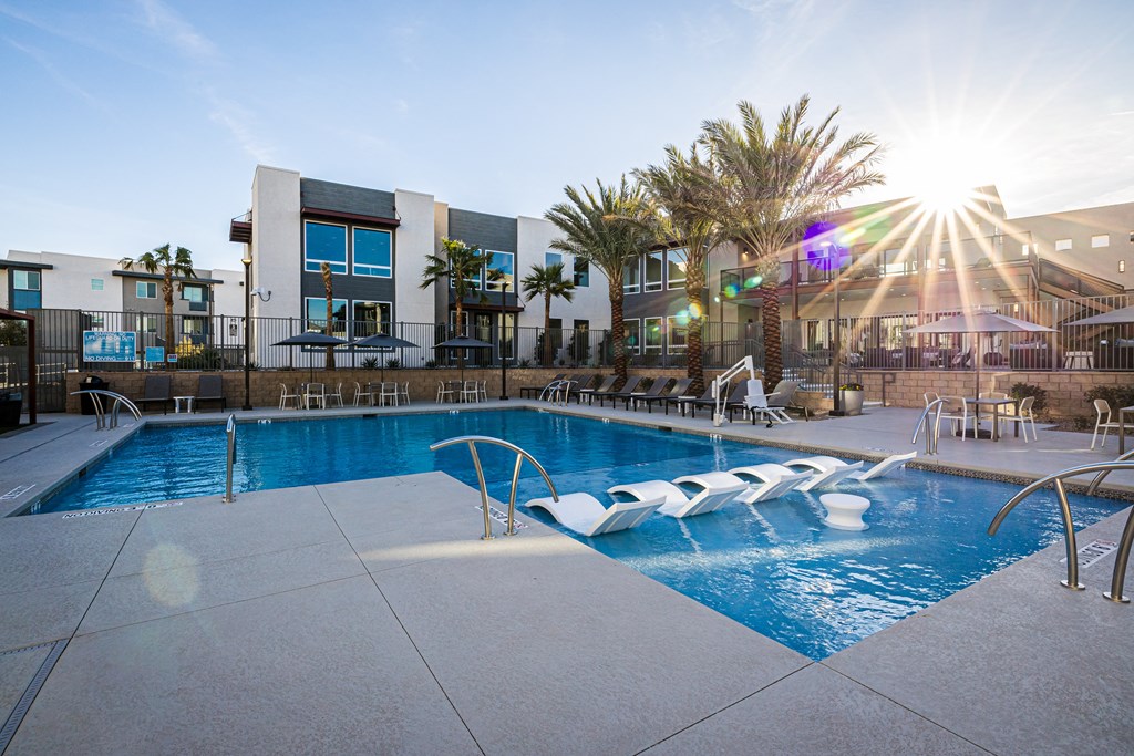 A sunny day at the pool with a building in the background.
