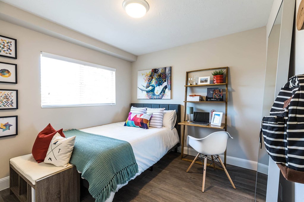 a bedroom with a bed and a desk with a chair a bedroom with a bed and a desk with a chair at Mountain Run Apartments, Utah