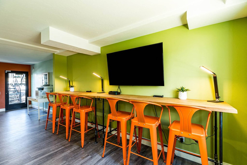 a long bar with chairs and a tv on the wall at Mountain Run Apartments, Orem