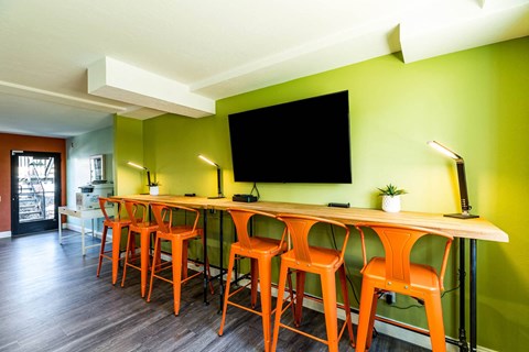 a long bar with chairs and a tv on the wall at Mountain Run Apartments, Orem