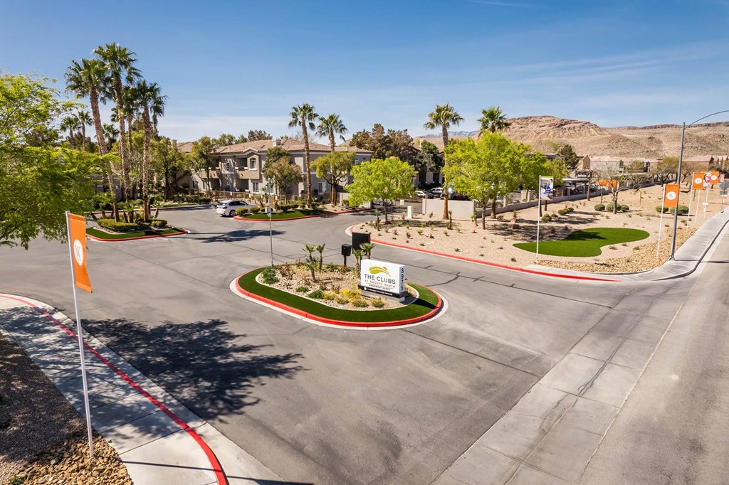 a street with an intersection and palm trees and houses
