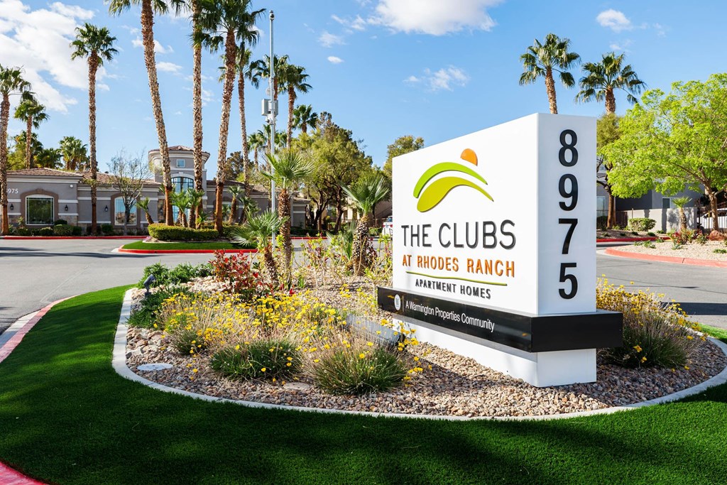 the clubs at hoses ranch sign in front of lawn and palm trees